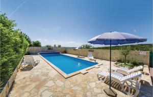 una piscina con sombrilla y sillas en Beautiful Apartment In Vrana With Wifi, en Vrana
