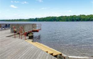 a dock with a bench on the side of a lake at Stunning Home In Tingsryd With Wifi in Tingsryd +16 photos