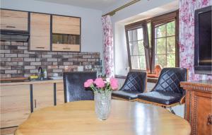 a vase with pink flowers on a wooden table at Gorgeous Apartment In Rydzewo in Rydzewo