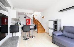 ein Wohnzimmer mit einer blauen Couch und einer Küche in der Unterkunft Nice Home In Puerto Rico De Gran Ca in Puerto Rico de Gran Canaria