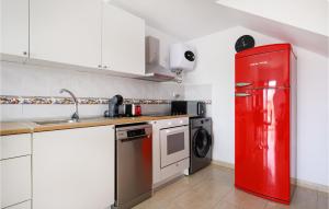 eine Küche mit einem roten Kühlschrank und einer Spüle in der Unterkunft Nice Home In Puerto Rico De Gran Ca in Puerto Rico de Gran Canaria