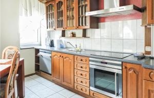 a kitchen with wooden cabinets and a stove top oven at Cozy Apartment In Kolobrzeg With Wifi in Kołobrzeg