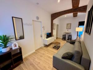 a living room with a couch and a table at Le Petit Hainaut, hyper centre in Valenciennes