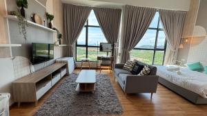 a living room with a couch and a tv at Dwin Studio Suites Imperium Residence Kuantan in Kuantan
