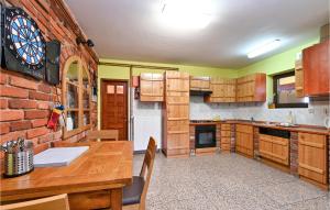 a kitchen with wooden cabinets and a brick wall at Nice Home In Sedlarica With Sauna in Sedlarica