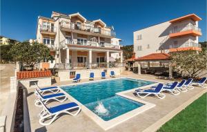 a house with a swimming pool and lounge chairs at Nice Apartment In Poljica in Poljica