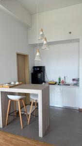 una cocina con una gran mesa de madera y 2 sillas en Dwin Studio Suites Imperium Residence Kuantan, en Kuantan
