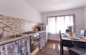 a kitchen with a sink and a table with a dining room at Pet Friendly Home In Gudovac With Wifi in Gudovac