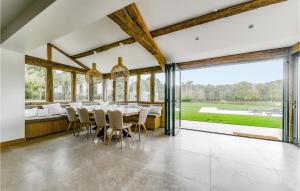 a dining room with a table and chairs and large windows at Cozy Home In Blancafort in Blancafort