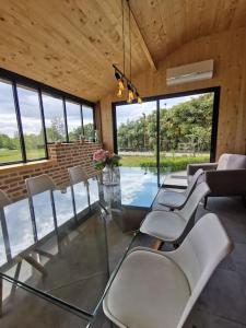 ein Esszimmer mit Stühlen und einem Glastisch in der Unterkunft Le Pti'Fernin, Gîte de Sologne in Saint-Viâtre