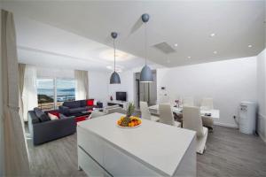 a white living room with a table and a dining room at Villa Red with pool and sea view in Makarska