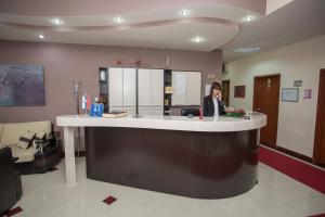 a woman sitting at a counter in a room at Sin-Kom Hotel Garni in Pirot