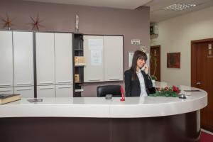 a woman in an office talking on a phone at Sin-Kom Hotel Garni in Pirot
