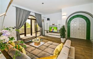 a living room with a couch and a tv at Pet Friendly Home In Jurdani With Sauna in Jurdani