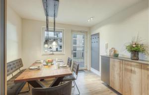 a kitchen and dining room with a wooden table and chairs at 2 Bedroom Cozy Apartment In Nordstrand in Nordstrand