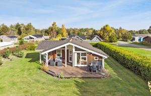 a house with a deck and chairs on a lawn at Nice Home In Væggerløse With Wifi in Bøtø By +8 photos