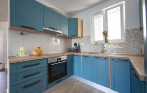 a kitchen with blue cabinets and a sink at 3 Bedroom Beautiful Home In Sutivan in Sutivan