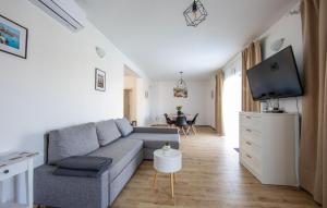 a living room with a couch and a tv at 3 Bedroom Beautiful Home In Sutivan in Sutivan