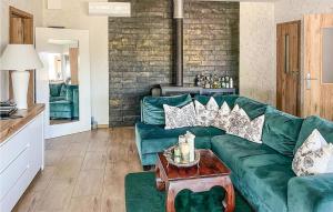 a living room with a green couch and a table at Nice Home In Insko With Sauna in Ińsko