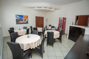 a dining room with tables and chairs with white table cloth at Sin-Kom Hotel Garni in Pirot