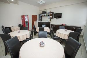 a dining room with white tables and black chairs at Sin-Kom Hotel Garni in Pirot