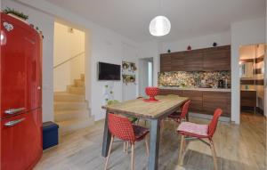 eine Küche mit einem Holztisch und roten Stühlen in der Unterkunft Cozy Home In Marina Di Ragusa With Wifi in Marina di Ragusa