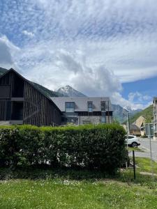 una casa con un seto delante de un edificio en Appt T2 à Saint-Lary-Soulan à 100m du centre, en Saint-Lary-Soulan