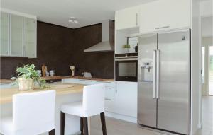 a kitchen with white cabinets and a stainless steel refrigerator at Gorgeous Home In Lammhult in Lammhult