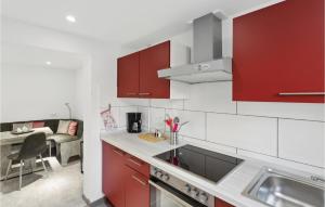 a kitchen with red cabinets and a kitchen sink at 1 Bedroom Lovely Apartment In Nieheim in Nieheim