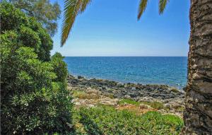 a view of the ocean from between two palm trees at Tanah Lot in Fontane Bianche +18 photos