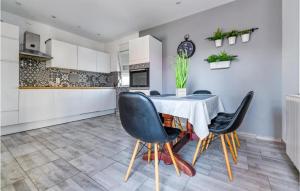 a kitchen and dining room with a table and chairs at 3 Bedroom Nice Home In Privlaka in Privlaka