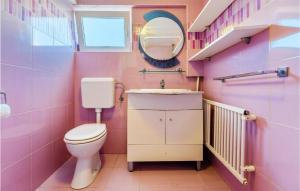 a pink bathroom with a toilet and a mirror at 3 Bedroom Nice Home In Privlaka in Privlaka +20 photos