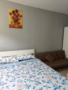 a bedroom with a bed with a blue and white comforter at Honrosa Studio at KBCC Service Apartment -with unifi in Kota Bharu +13 photos