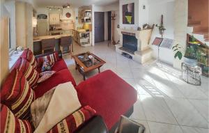 a living room with a red couch and a fireplace at 2 Bedroom Stunning Home In Abeilhan in Abeilhan