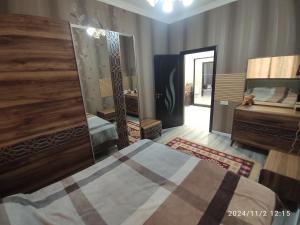 a bedroom with a bed and a large mirror at 3 комнат Центр Города всё рядом in Xirdalan