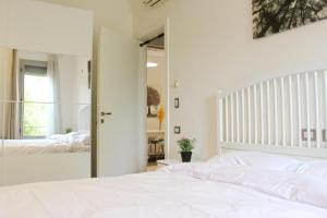 a bedroom with a white bed and a mirror at Modern 1BR Apartment in Palm Hills Near AUC New Cairo in Cairo