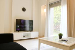 a living room with a tv and a glass table at Modern 1BR Apartment in Palm Hills Near AUC New Cairo in Cairo