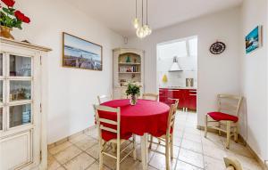 jadalnia z czerwonym stołem i krzesłami w obiekcie 2 Bedroom Gorgeous Home In Royan w mieście Royan