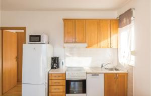 a kitchen with a white refrigerator and a sink at Apartment Vukovarska Iii in Makarska
