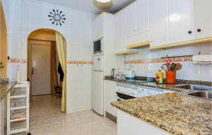 a kitchen with white cabinets and a counter top at Stunning Home In Pulpí in Pulpí