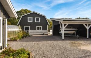 a black house with a garage and a boat at Amazing Home In Sturkö With Wi-Fi in Sturkö