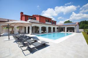 a villa with a swimming pool and lounge chairs at Residence Monaco for 10 people in Central Istria with 65 m2 private pool, large garden & spa in Svetvinčenat