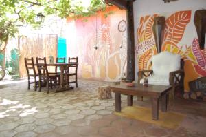 a room with chairs and a table and a wall at Posada Argimon in San Marcos Sierras