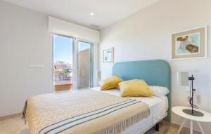 Schlafzimmer mit einem Bett mit blauem Kopfteil und einem Fenster in der Unterkunft Beach Front Apartment in Pilar de la Horadada
