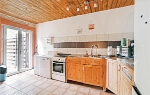 eine Küche mit weißen Geräten und Holzschränken in der Unterkunft 2 Bedroom Lovely Apartment In Codognan in Codognan