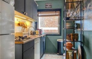a small kitchen with blue cabinets and a window at Gorgeous Apartment In Katwijk Aan Zee in Katwijk aan Zee