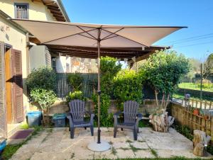 un patio con due sedie e un ombrellone di Villa Anna near Rome a Anguillara Sabazia