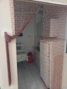 a kitchen with a window with a curtain and a microwave at Γκαρσονιέρα κοντά στο πανεπιστήμιο, περ κόμβος ΤΕΙ in Kozani