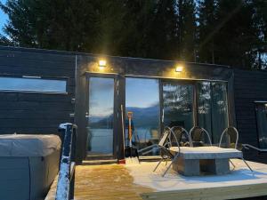 a house with a table and chairs in front of it at Aurora Lodge Retreat in Ytre Tomasjord