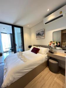 a bedroom with a large white bed and a sink at Edge centarl pattaya luxury sea view in Ban Khok Kham